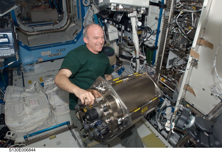 Astronaut Jeff Williams installs a Distillation Assembly into the Urine Processor Assembly on the ISS.