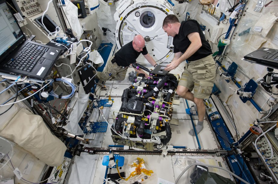 Astronauts Scott Kelly and Terry Virts are seen replacing a faulty fan on one of the space station's two Carbon Dioxide Removal Assemblies.