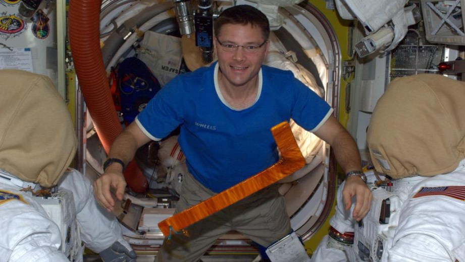 Doug Wheelock shows off the improvised "hockey stick" tool that was used by his spacewalking partner, Scott Parazynski, to untangle a snagged solar array.