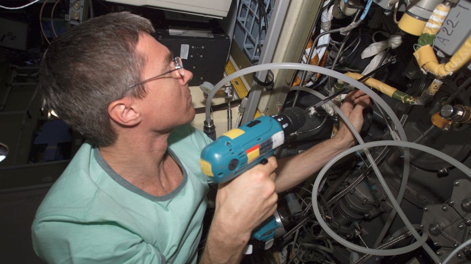 Cosmonaut Sergei Krikalev, Expedition 11 commander, uses a power tool as he makes repairs to the Elektron oxygen generator in the Zvezda Service Module of the International Space Station.