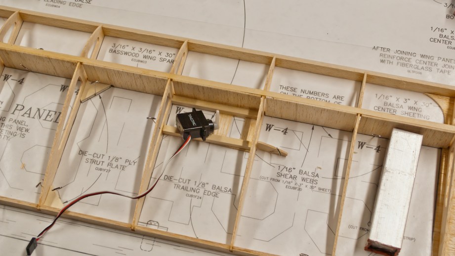 Model airplane wings are constructed much like those on full-scale airplanes. Here you can see how the Cub's wing is assembled over the plans.